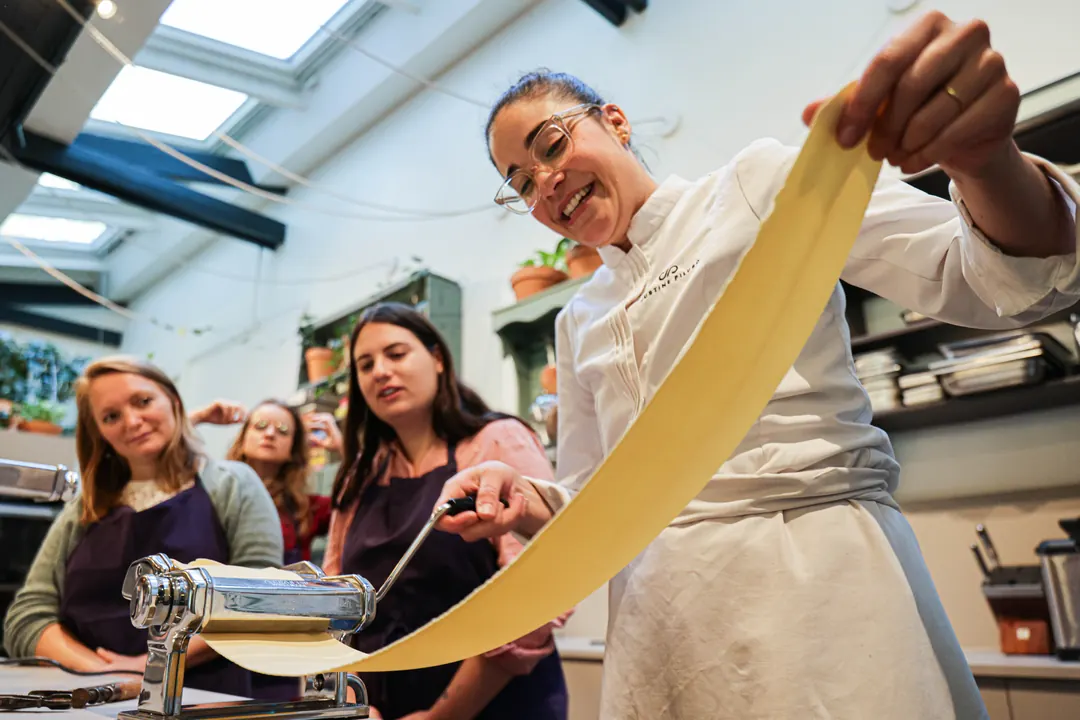 Justine étire une pâte fraîche pendant un cours